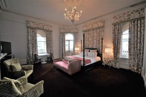阿德莱德拉格斯码头酒店的一间卧室配有一张床、一把椅子和一个吊灯。