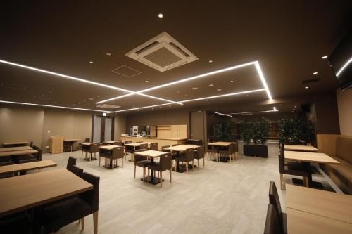 东京多美迎后乐园酒店的用餐室配有桌椅和灯光