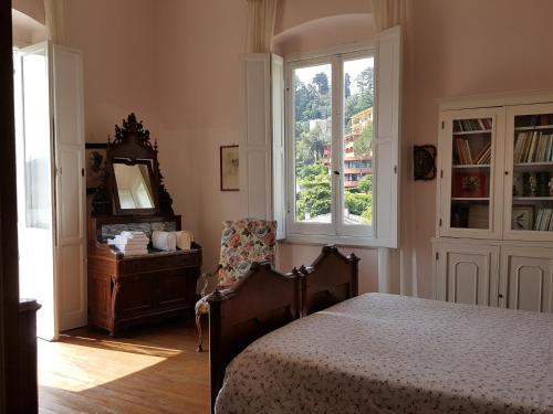 拉帕洛Villa Olimpo的一间卧室设有一张床、一个窗口和一把椅子