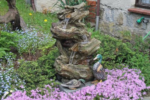 滨湖克拉科Ferienquartiere Roloff的花卉花园中喷泉的雕像