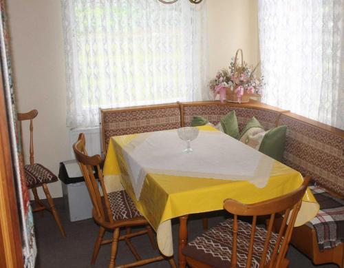 滨湖克拉科Ferienquartiere Roloff的用餐室配有黄色的桌子和椅子
