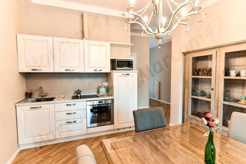 博洛尼亚Marconi 47 Suite的厨房配有白色橱柜和桌椅
