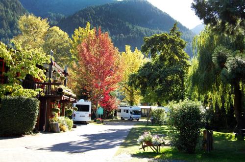 皇后镇Queenstown Holiday Park Creeksyde的一群人停在一个树木繁茂的院子中