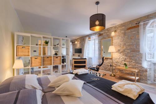 罗维尼Luxury Apartment Fabris的一间卧室设有一张大床和石墙