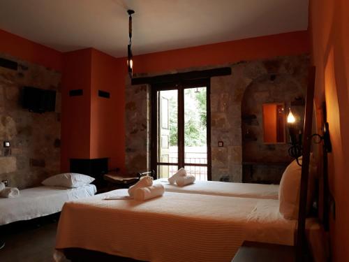 美西尼Messana的橙色墙壁和窗户的客房内的两张床