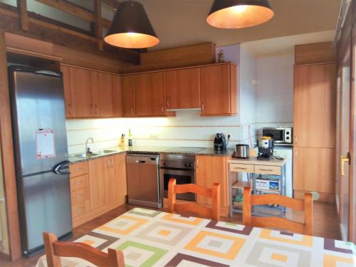 普奇塞达Apartamento Mirador Del Puigmal的厨房配有木制橱柜和不锈钢用具