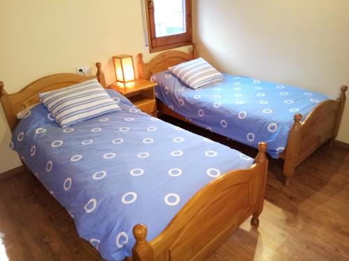 普奇塞达Apartamento Mirador Del Puigmal的两张睡床彼此相邻,位于一个房间里