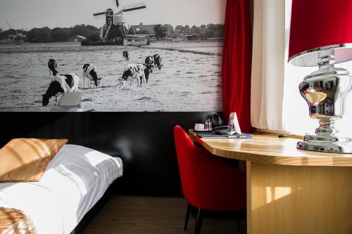 乌赫斯特海斯特奥格斯特吉斯特巴斯蒂欧酒店的酒店客房设有一张桌子、一张床和一张桌子,里面放着牛