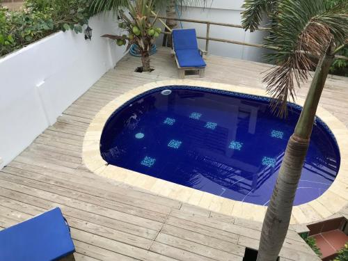 卡塔赫纳Hotel Palmera Beach Cartagena的一个带棕榈树和蓝色椅子的游泳池