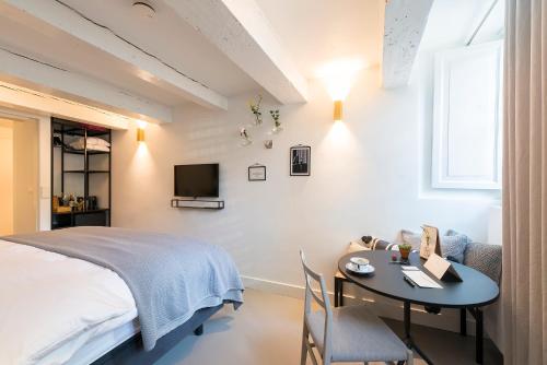 阿姆斯特丹阿姆斯特丹牛奶屋奢华住宿加早餐旅馆的一间卧室配有一张床、一张桌子和一台电视。