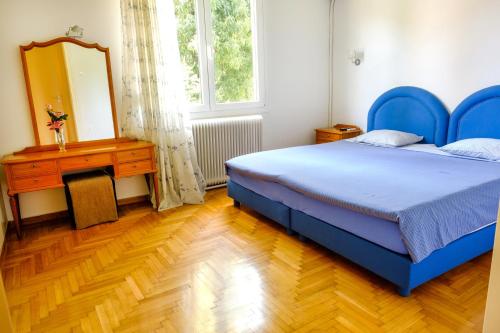 雅典Chalandri Home Away的一间卧室配有蓝色的床、梳妆台和镜子