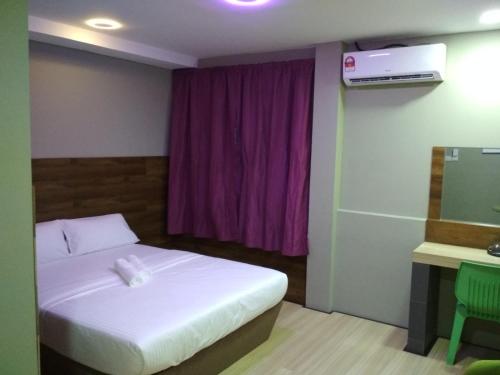 斯里巴加湾市Qing Yun Rest House Gadong, Brunei Darussalam的一间卧室设有一张床和一个紫色的窗户