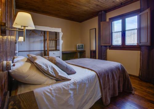 Pepín科尔蒂纳阿尔迪乡村的卧室配有带枕头的床铺和窗户。