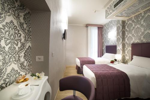佛罗伦萨蒙特利尔酒店的酒店客房设有两张床和一张带水槽的桌子。