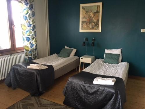 耶利瓦勒Pensionat Augustin的客房设有两张单人床和蓝色的墙壁。