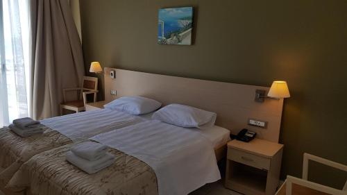 扎哈罗Ostria Hotel Kakovatos Beach的一间卧室配有带白色床单和枕头的床。