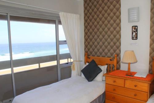 阿曼济姆托蒂Silver Dolphin Holidays的一间卧室设有一张床和一个海景窗户