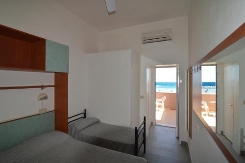 里米尼Hotel VistaMare Viserba的一间带两张床的卧室,享有海滩美景