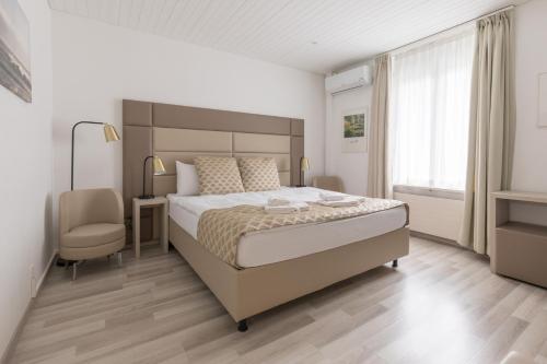 苏黎世穆茨舍伦酒店的一间卧室配有一张大床和一把椅子
