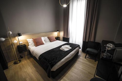 罗马SuiteLifeTrevi的卧室配有床、椅子和窗户。