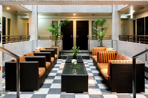 东京上野酒店的大堂配有沙发、桌子和植物
