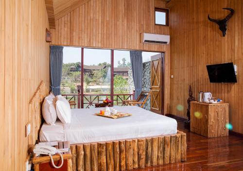 勃固KMA SHWE PYI BAGO Resort的一间卧室设有一张床和一个大窗户