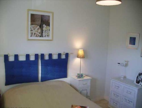 滨海卡约信号酒店的一间卧室配有一张床和一张桌子上的台灯