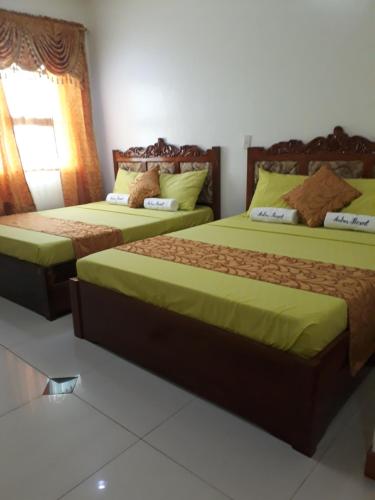 NabasAndres Resort的一间卧室设有两张带绿床单的床和窗户。