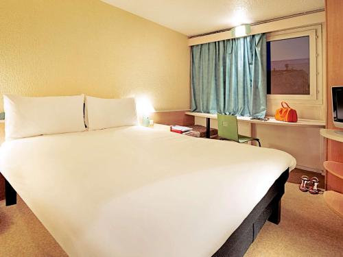 布隆里昂东布隆宜必思酒店的窗户客房内的一张大白色床