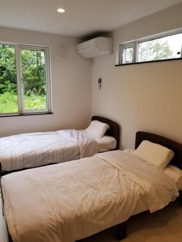富良野富良野山别墅的带2扇窗户的客房内的2张床
