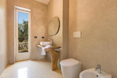 卡萨拉诺Villa Satis by BarbarHouse的一间带水槽、卫生间和镜子的浴室