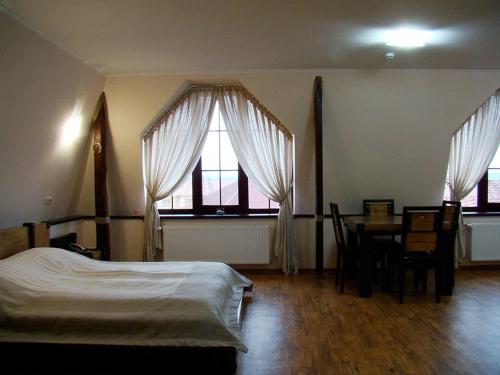 Kozlin金马蹄酒店的卧室配有床、桌子和窗户。
