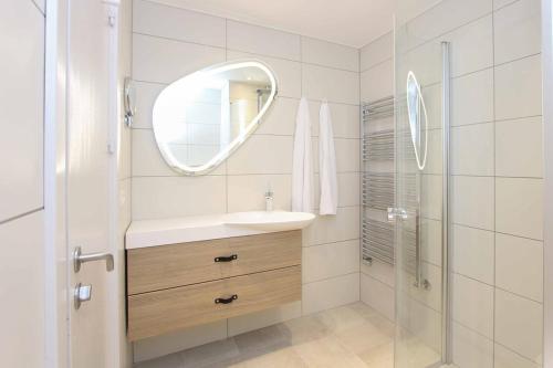 伦讷Fredensborg Badehotel的白色的浴室设有水槽和镜子