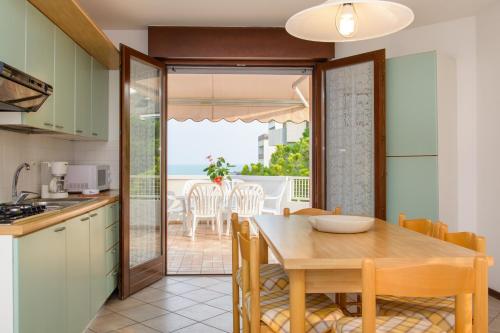 利尼亚诺萨比亚多罗Appartamenti Lignano Sabbiadoro - Villa Ammiraglia的一间厨房和带桌子的海景用餐室