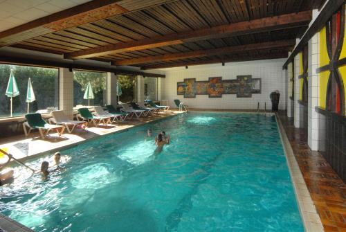 拉姆绍达赫斯坦考博尔豪夫酒店的游泳池,有水中的人
