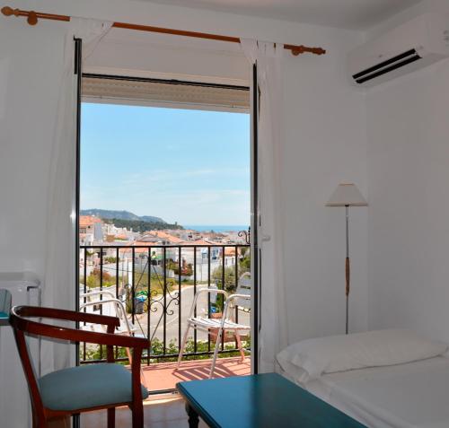 内尔哈安达卢斯酒店的一间卧室设有1张床铺和1张桌子的阳台