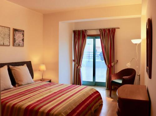 阿尔布费拉Algarve Sweet Home - Marina Front的卧室配有床、椅子和窗户。
