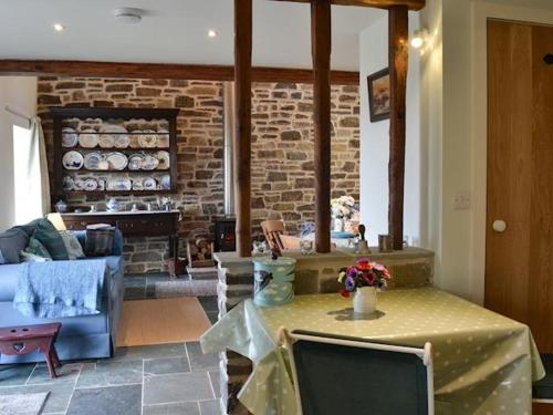 勒兰蒂德威尔斯Swallow Barn的客厅配有桌子和砖砌壁炉