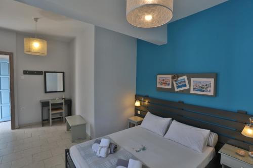 金尼昂Kini Bay的一间卧室设有一张床和蓝色的墙壁