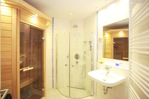 瓦尔内明德酷派欧亚瑟公寓的带淋浴、盥洗盆和淋浴的浴室