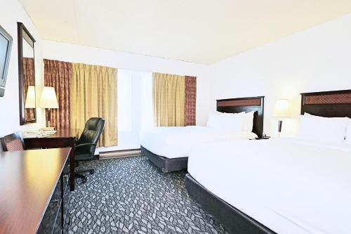 蒙特利尔勒鲁克斯酒店的酒店客房配有两张床和一张书桌