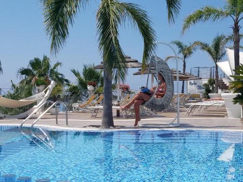 帕尔盖利亚波尔图乌丽赛住宅酒店的一位女士站在游泳池旁边
