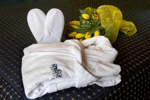 弗利玛斯尼酒店的一双毛巾和一束鲜花