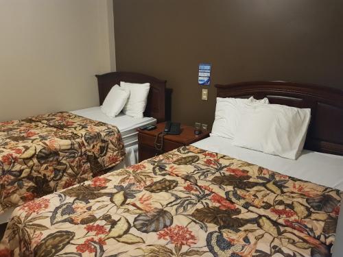 圣米格尔Hotel Florencia的酒店客房设有两张床和床头柜。