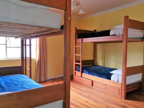 基多Community Hostel Quito的铺有木地板的客房内配有两张双层床。