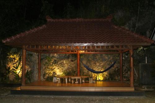 巴图卡拉Sederhana Homestay的凉亭配有长凳和桌子