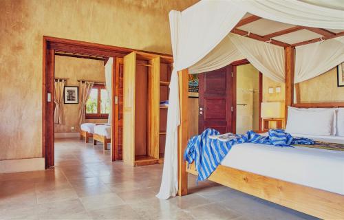乌鲁瓦图三只猴子别墅酒店的一间卧室配有一张带天蓬的床