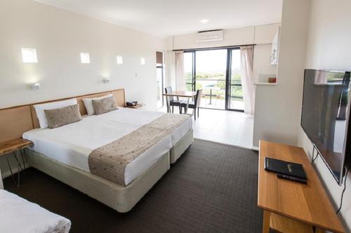 玛格丽特河玛格丽特海滩度假酒店的酒店客房设有一张大床和一张桌子。