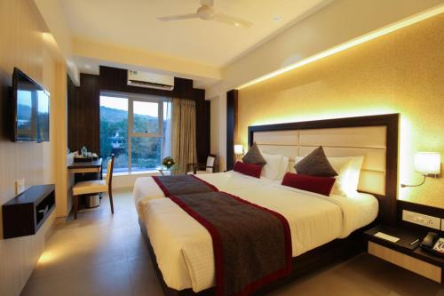 纳威孟买Hotel Vista Inn的酒店客房设有一张大床和一张书桌。