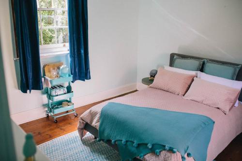 AuburnTerroir Auburn的一间卧室配有一张带蓝色窗帘的床和一扇窗户